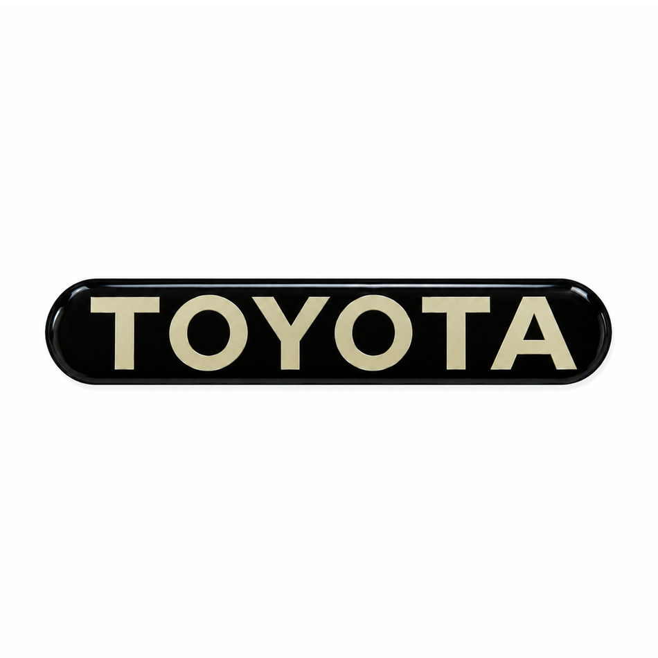 OEM-style TOYOTA steering wheel emblem decal with light gold lettering on a glossy black oval for 1990-1991 4Runner SR5 4WD and 1989-1991 Pickup SR5 4WD