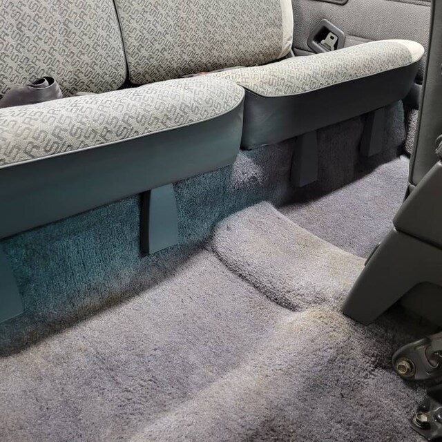 Gray rear seat hinge covers installed below a folded rear seat in a 1984-89 Toyota 4Runner