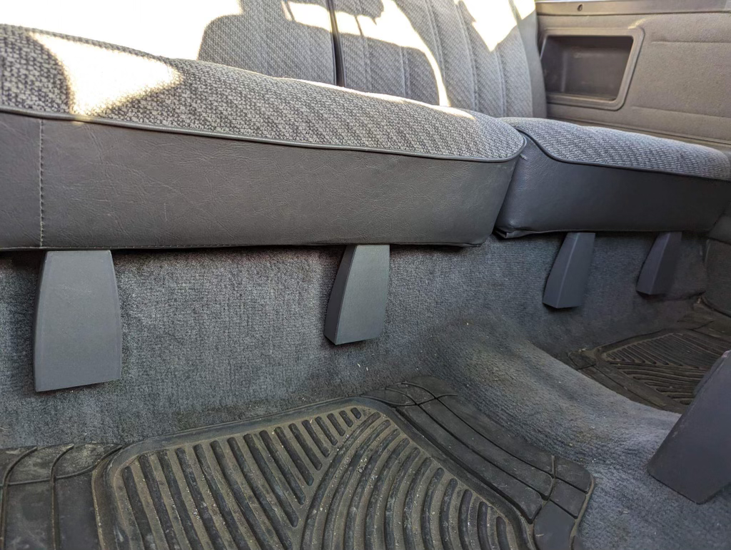 Gray rear seat hinge covers installed beneath the rear seat of a 1984-89 Toyota 4Runner
