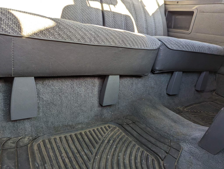 Gray rear seat hinge covers installed beneath the rear seat of a 1984-89 Toyota 4Runner