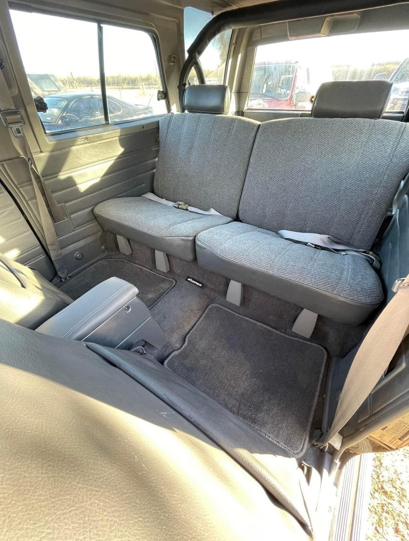 Blue rear seat hinge covers installed beneath the rear seat of a 1984-89 Toyota 4Runner